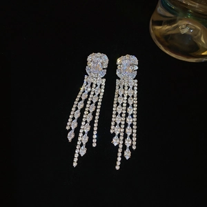 Macro view of silver tassel earrings with square cubic zirconia on black matte background
