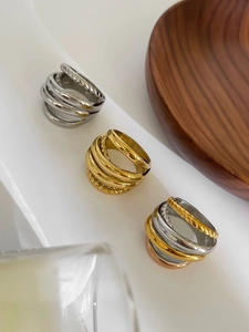 Detail of stacked multi-layer rings in gold and silver with twisted rope texture