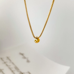 Macro view of a gold-plated moon pendant on a delicate box chain necklace