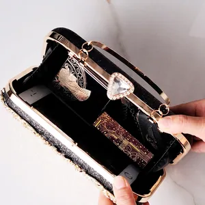 Black evening clutch with gold frame, crystal clasp, and rhinestones holding essential items