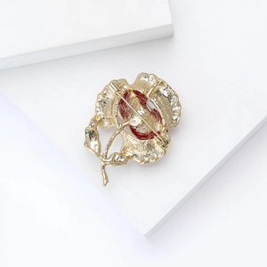 Detailed back view of golden enamel pansy brooch showing pin fastener and red petals