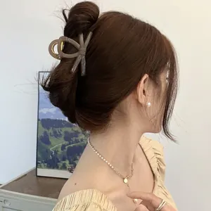 Elegant brown matte bow hair claw clip styled on a model with premium jewelry