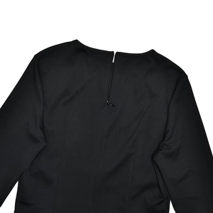 Detailed view of back zipper closure and ribbed knit texture on a black slim dress