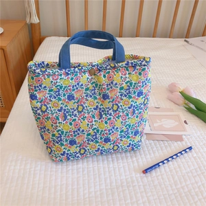 Detailed view of floral canvas lunch bag featuring thick cotton and golden snap button closure