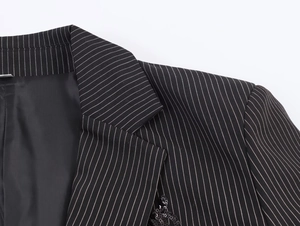 Close-up of black pinstripe blazer featuring exquisite sequin embellishments on lapel