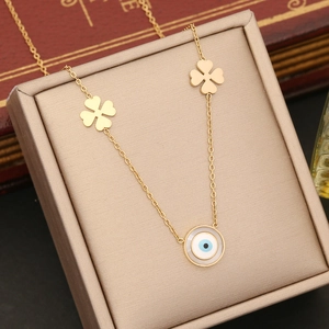 Detailed close-up of gold stainless steel necklace with clover and blue evil eye pendant