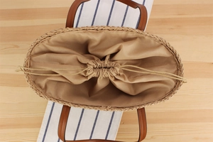 Makroansicht der Papierschnur-Tasche mit Kordelzug-Innenfutter und Ledergriff-Details