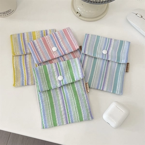 Detailed set of four striped fabric pouches with snap closures in multiple pastel colors