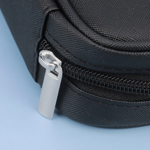 Detail shot of a black waterproof makeup brush bag with a durable silver metal zipper closure