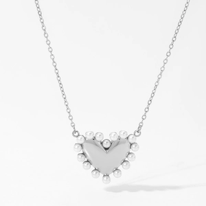 Détail du pendentif cœur argenté entouré de perles blanches sur une fine chaîne collier