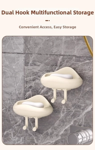 Detail of cream cloud-shaped soap dish with dual hooks on marble wall mounting