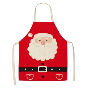 Flat lay view of a red linen Christmas apron featuring a cartoon Santa Claus face print