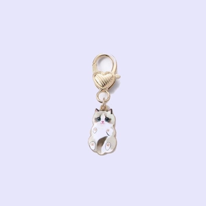 Detail of zinc alloy cat pendant with purple enamel finish and gold heart clasp
