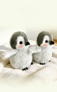 Nahaufnahme von zwei niedlichen Pinguin-Plüschtieren mit weichem grau-weißem Kunstfell
