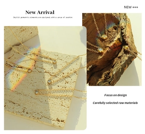 Detailed view of a gold plated zircon pendant necklace on rustic stone and wood