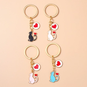 Detail view of four creative cat-shaped metal keychains with gold-plated heart pendants