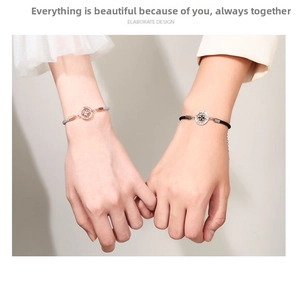 Détail de bracelets de couple tressés avec breloques d'étoile portés au poignet