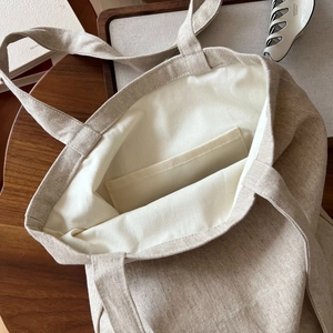 Détail intérieur d'un cabas en toile beige montrant la poche interne et la texture du tissu