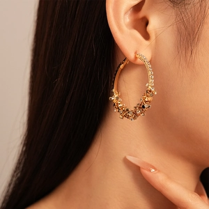 Macro shot of large golden hoop earrings with sparkling crystal clusters for fashion