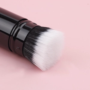 Macro shot of dense black and white gradient bristles on a sleek retractable makeup brush