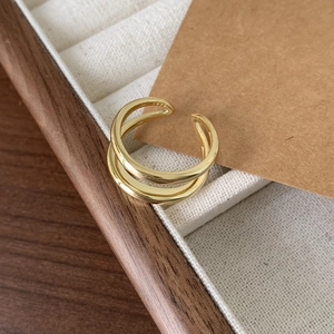 Detailed shot of double-layered gold S925 silver ring on a minimalist wooden tray