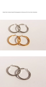 Macro detail shot showing the spiral spring texture of gold and silver hoop earrings