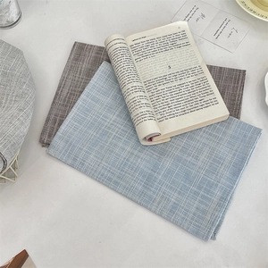 Close-up of blue linen grid placemat under a book in a lifestyle setting