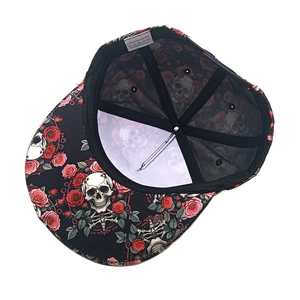 Detail of flat brim snapback featuring skeleton rose print and polyester fabric tag