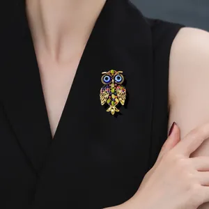 Luxury owl brooch with colorful rhinestones on gold alloy base pinned to black lapel