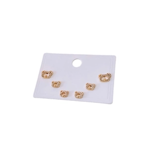 Three pairs of golden bear earrings with shimmering crystals on white display card