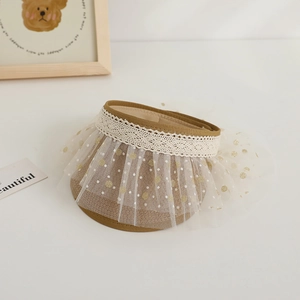 Detail of kids straw sun visor with white lace trimming and polka dot mesh decoration