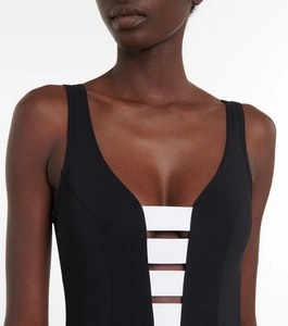 Detail of V-neckline on black and white color-block one-piece swimsuit with striped cutouts