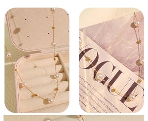 Detailed view of 18K gold star pearl necklace on a soft pink jewelry box background