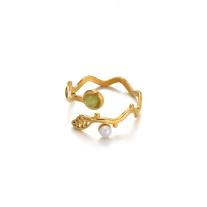 Anello aperto a foglia dorata con pietra verde e perla bianca su sfondo bianco