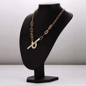 Gold stainless steel link chain necklace with crystal U-shape pendant on black mannequin