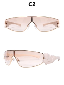 Detail of pink Y2K sunglasses with gold metal frame and white heart charm on the temple