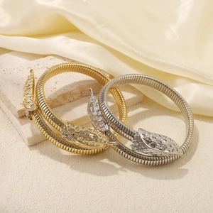 Luxurious gold and silver spiral snake bracelets with intricate scale texture and crystals