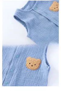 Detail of light blue baby romper featuring breathable cotton gauze and a cute bear patch