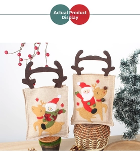 Close-up of linen Christmas gift bags with reindeer and snowman felt embroidery