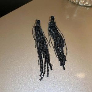 Detailed macro view of cascading black rhinestone tassel earrings with a long elegant drape