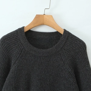 Detail of dark grey crewneck knit sweater with chunky texture and raglan sleeves
