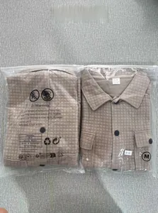 Detail of khaki quilted shirt in PE bag showing size M label and grid fabric texture