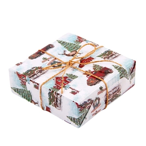 Christmas gift box wrapped in vintage paper with red trucks and trees tied with hemp rope