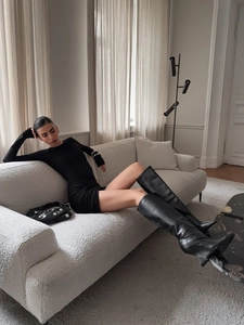 Slim fit black long sleeve mini dress paired with stylish black leather high boots