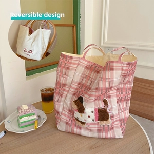 Detail of pink plaid canvas tote bag with brown dachshund embroidery and Faith mole text