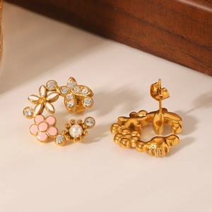 Détail de boucles d'oreilles fleur en acier doré 18K avec émail rose, cristaux et perles