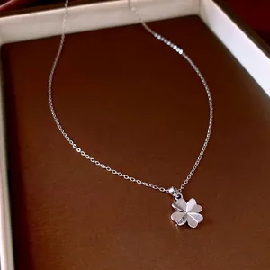 Elegant silver four-leaf clover pendant necklace displayed in a luxury jewelry box