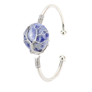 Macro detail of handmade wire wrapped round blue stone bracelet with tree of life pattern