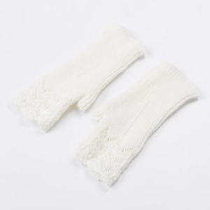 Close-up of white knit fingerless gloves with delicate fish scale texture and hollow pattern