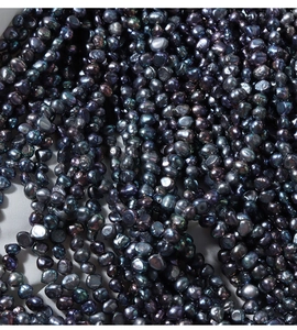 Macro shot of irregular black baroque freshwater pearls with rainbow metallic luster